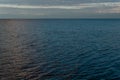 View of the clear calm undulating .ripples water of Lake Baikal, sunset clouds on the horizon, sky Royalty Free Stock Photo