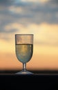 AN ENTICING GLASS OF WHITE WINE WITH AN AFRICAN SUNSET BEHIND Royalty Free Stock Photo