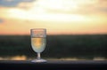 SUNSET THROUGH GLASS WITH WHITE WINE Royalty Free Stock Photo