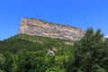 View of a cliff surrounded by green vegetation. Rocher du Caire, Remuzat, France. Royalty Free Stock Photo