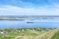 View from the cliff to the Volga river, suburban buildings, coastline, tanker going along the river