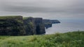 view of the Cliffs of Moher in Ireland with rugged coastline and cloudy sky Royalty Free Stock Photo