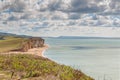 View from clifftop at a golden beach with people enjoying walking and coastline of West Bay Royalty Free Stock Photo