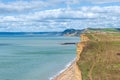 View from clifftop at a golden beach with people enjoying walking and coastline of West Bay Royalty Free Stock Photo