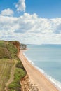 View from clifftop at a golden beach with people enjoying walking and coastline of West Bay Royalty Free Stock Photo
