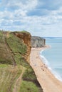 View from clifftop at a golden beach with people enjoying walking and coastline of West Bay Royalty Free Stock Photo