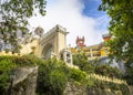 View of the clock tower, wall and palm trees in the Pena National Palace in Sintra town, Portugal Royalty Free Stock Photo