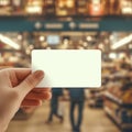 view Close up hand extends a blank credit card at grocery entrance