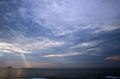 FLEECE CLOUD OVER THE SEA AT SUNSET WITH SUNBEAMS BREAKING THROUGH IN THE DISTANCE Royalty Free Stock Photo