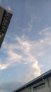 view of cloudy sky between buildings in Kartasura