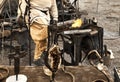 View of coal basin of ancient forge with burning charcoal and intentionally blurred workpieces in foreground