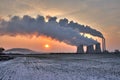 View of coal powerplant against sun and huge fumes