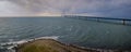 View from the coast of Denmark, one can see the StorebÃ¦lt Bridge spanning across the horizon, connecting the two coasts.