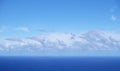 View from the coast of the Easter Island, of blue sky covered by white clouds, over the Pacific Ocean. Royalty Free Stock Photo