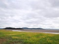 View of the coast at grange over sands in cumbria with grass covered wetland in the foregrounds and the north lake district area