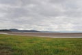 View of the coast at grange over sands in cumbria with grass covered wetland in the foregrounds and the north lake district area