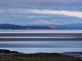 View of the coast at grange over sands in cumbria at twilight with grass covered wetland in the foregrounds and the lake district