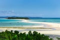 View of coastline of Iranja Island, Nosy Iranja lined with palm trees and boats floating in the sea, Madagascar Royalty Free Stock Photo