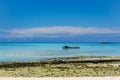 View of coastline of Iranja Island, Nosy Iranja lined with palm trees and boats floating in the sea, Madagascar Royalty Free Stock Photo