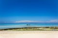 View of coastline of Iranja Island, Nosy Iranja lined with palm trees and boats floating in the sea, Madagascar Royalty Free Stock Photo