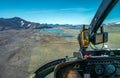 View from cockpit of small helicopter on lakes and mountains in vast Arctic landscape. Balgatjavrasj lake plateau in