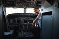 Mirthful experienced pilot looking happy at his workplace