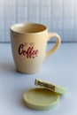 View of a coffee cup with lettering full with black coffee together with round cookies