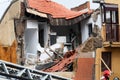 View of a collapsed building with dust and rubble after an explosion while firefighters decide what to do.