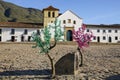 View through colorful decoration to the Church of our lady of the rosary at Plaza Mayor of Villa de Leyva, Colombia