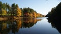 Colorful forest of New England in Autumn with red, green, yellow and orange leafs reflecting in a lake river Royalty Free Stock Photo