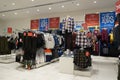 A view of colorful kid blouses and shirt hanging on the cloth rack in the shop. Variety of beautiful baby girl and boy dresses on