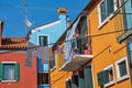 View of colorful terraced houses, balcony and clothes hanging in an alley in Burano. Royalty Free Stock Photo