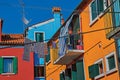 View of colorful terraced houses, balcony and clothes hanging in an alley in Burano. Royalty Free Stock Photo