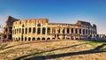 View of the Colosseum adjacent to Via Dei Fori Imperiali on a summer evening