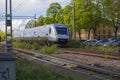 View of coming speed electric train passing crossroad in town.