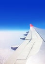 View of a commercial aeroplane from window where you can see the wing which flies above the clouds.