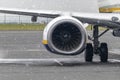 View of commercial airplane engine running while starting to snow