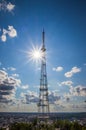 View of communication towers with blue sky, sun, mountain and cityscape background. Top view of the radio tower in the city Royalty Free Stock Photo