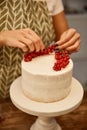 View of confectioner putting juicy redcurrant