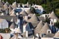 View of the conical roofs of the traditional white washed trullo dry stone houses in Alberobello in Puglia Italy.
