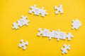 View of connected and unfinished puzzle pieces isolated on yellow Royalty Free Stock Photo