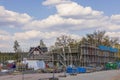 View of construction site fenced with fence with houses under construction.