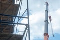 View of the construction site, scaffolding installed around the old building. The boom of the tower crane hangs over the temple Royalty Free Stock Photo