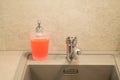 View of a container of liquid soap on a gray kitchen sink, clean house Royalty Free Stock Photo