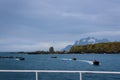 View of Coopers Bay landscape from cruise ship, fleet of inflatable rafts with drivers in red jackets getting ready to pick up tou