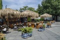 View of cosy nook for summer relaxation below palm sunshade with bar, table, chair and wooden bench, park Borisova gradina Royalty Free Stock Photo