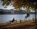 View of a couple and a man sitting on the riverside benches of a park in Copenhagen Royalty Free Stock Photo