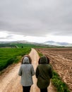 View of couple walking on a dirt road in beautiful parkland