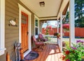 View of cozy covered porch with chairs and flower pots