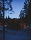 View of a cozy wooden scandinavian cabin cottage chalet house covered in snow near ski resort lodge in winter with the christmas